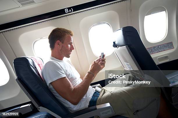 Путешествия Человек Сидит Sms На Мобильный Телефон В Сиденье Самолёта — стоковые фотографии и другие картинки Беспроводная технология