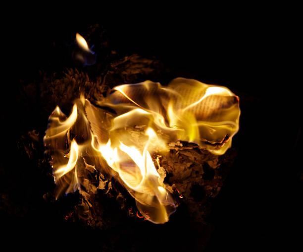 Bookburning at night Flames engulf a book during a night-time book-burning ceremony.Alternatives: book burning stock pictures, royalty-free photos & images