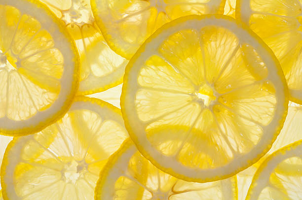 Lemons Backlit Lemon Slice Background lemon fruit stock pictures, royalty-free photos & images