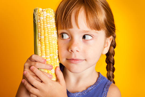 istock Little Red-Haired Girl Holding Corn on the Cob 182930874