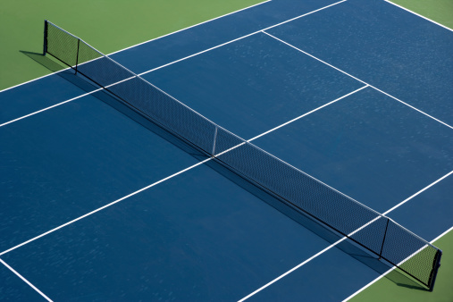 Aerial photo of blue tennis courts with white lines and light blue pickleball lines