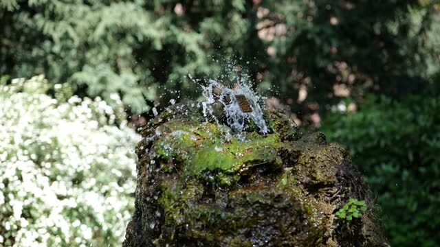 Slow-motion of water pouring from a small fountain