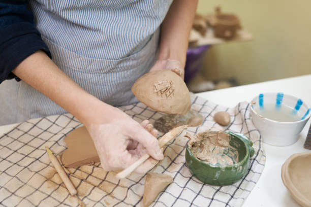 istock woman forming clay pot shape by hands, closeup in artistic studio 1829337882