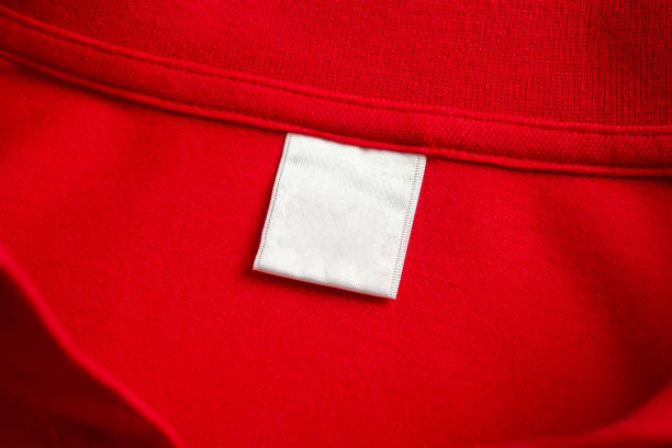 istock Blank white laundry care clothes label on red shirt fabric texture background 1829346909