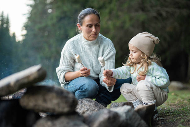 istock Family camping at lake, roasting marshmallows on campfire. 1829353413