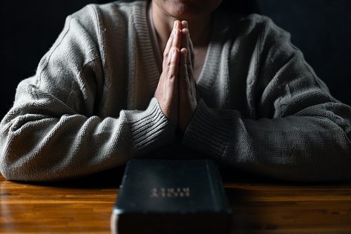 Christian life crisis prayer to god. Woman Pray for god blessing to wishing have a better life. woman hands praying to god with the bible. begging for forgiveness and believe in goodness.