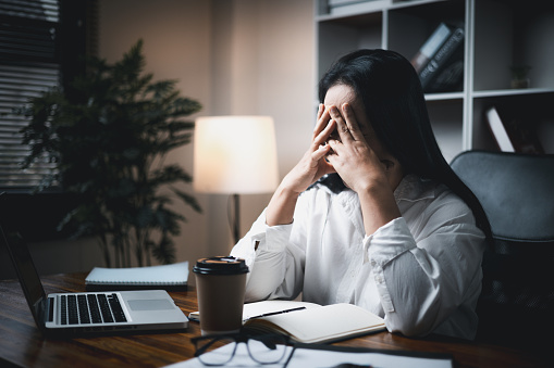 A woman battles depression and stress in her workplace, highlighting the challenges faced by professionals. This image captures the impact of mental health on employees in a corporate environment.