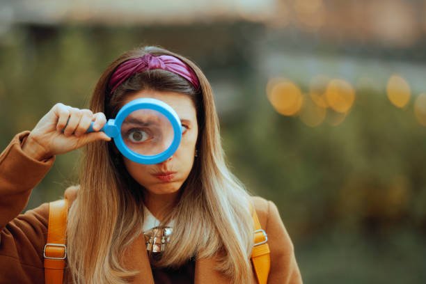 istock Funny Curious Woman Looking Through a Magnifying Glass 1829380072
