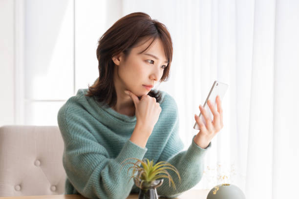 Asian woman using a smartphone,think, stock photo