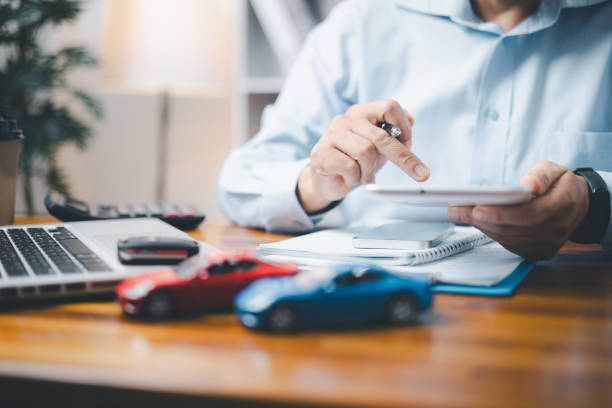 coche de juguete frente a un hombre de negocios calculando el préstamo. ahorro de dinero para el concepto de automóvil, cambio de automóvil por concepto de efectivo, concepto de finanzas. - car loan fotografías e imágenes de stock