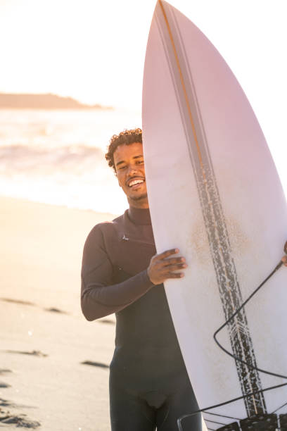 istock Surfer smiles holding his surfboard. 1829453713