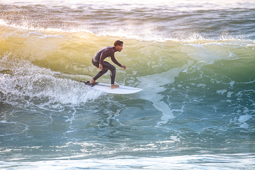 Young surfer with with wetsuit enjoying big waves.