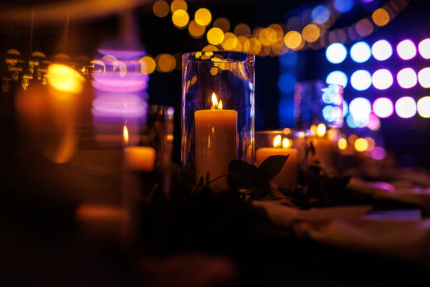 istock A romantic table setting with lit candles and greenery at a nighttime event. 1829479641