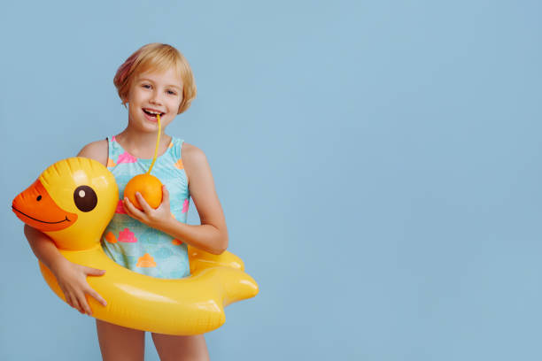 istock Child with inflatable duck ring on blue background with copy space. 1829505862