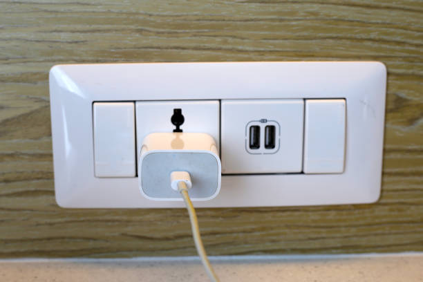istock Hand insert a plug of the phone charger into socket. 1829545451