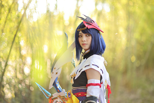 Japanese young woman hunter cosplay with bow on Japanese garden