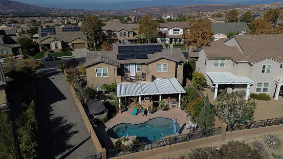 A woman enjoys some time in the backyard of a California home. Solar panels show that one can enjoy a nice home while doing their best to create clean energy.