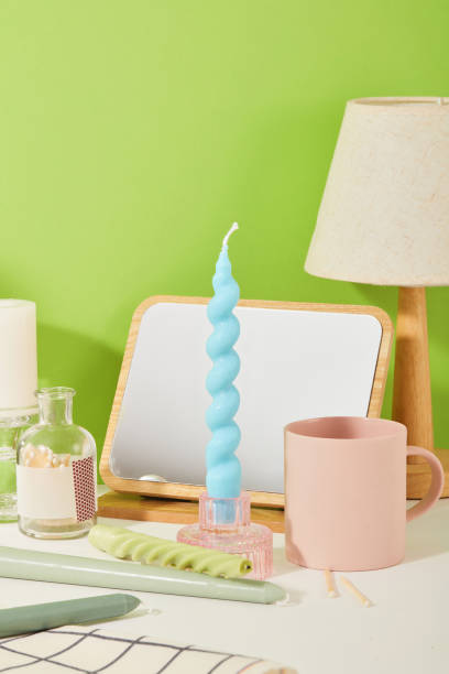 istock A blue candle is inserted into a glass candlestick. On the table there are many utensils such as mirror, ceramic cup, lamp, etc. Delicate images suitable for many themes. 1829679443