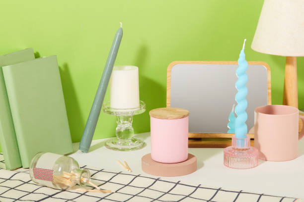 istock Display of scented and colored candles with props on a table. Checkered tablecloth against a green background. Versatile candles for lighting and decoration purposes. 1829680196