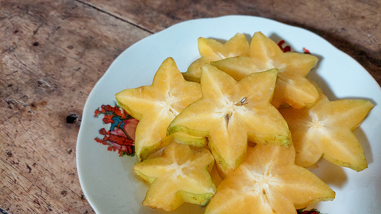 star fruit on plate with wooden background