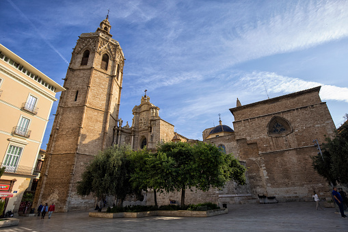 Exterior view of Valencia Cathedral in the morning, Spain. People walking by.