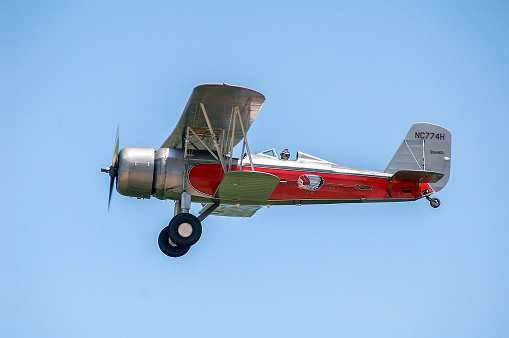 Stearman biplane in Western Air Express livery flying in blue sky. Hastings, Nebraska, USA June 22, 2008.