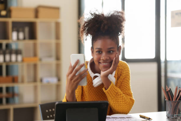 istock Cute female college student using smartphone to video call with friend. 1829695486