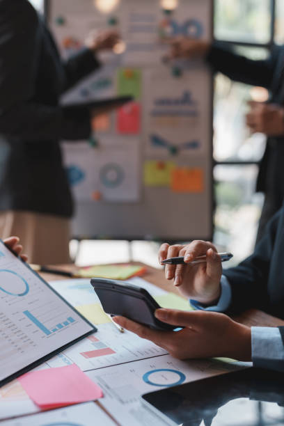 istock Business people in a meeting and using a calculator to calculate, plan, analyze, create graphs and charts to show business growth to plan new business expansions in the future. 1829697775