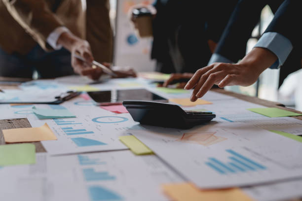 istock Business people in a meeting and using a calculator to calculate, plan, analyze, create graphs and charts to show business growth to plan new business expansions in the future. 1829697776