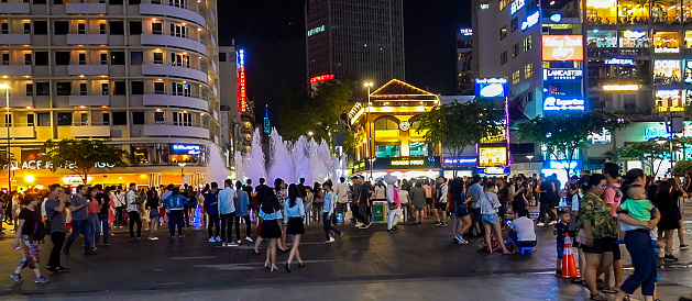 Ho Chi Minh City, Vietnam- September 9, 2019: Large crowd of people enjoying a night in a large downtown plaza.