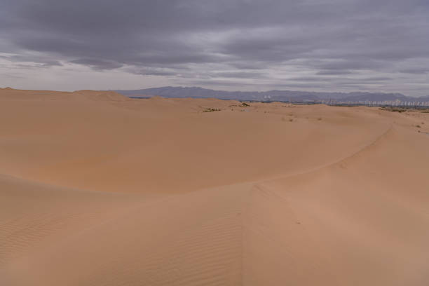Dramatic sky over the never-ending sand dunes of the Gobi desert in Inner Mongolia, China. Background with copy space for text