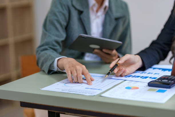 istock Businesspeople at a meeting pointing at graphs to calculate, plan, analyze, create graphs and charts to show business growth to plan new business expansion in the future. 1829710381