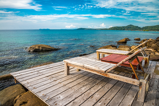 Lounge chair in beautiful tropical island rock beach - Ko Kut, Trat Thailand. Travel summer beach holiday, relaxation, nature concept.