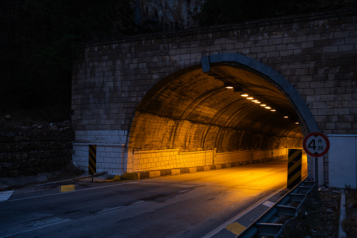 Illuminated tunnel through a mountain.