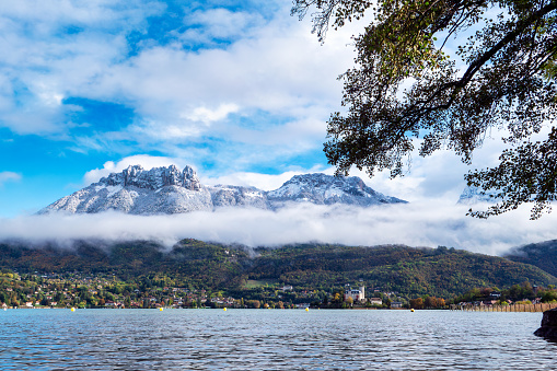 a view of Annecy lake, autumn, snow on the mountain