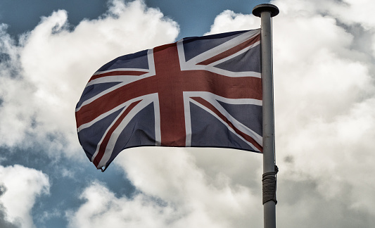 Official national Great Britain Flag, waving in the wind. 3D illustration of United Kingdom flag, Union Jack silk satin texture, isolated on abstract sky background. UK english symbol design element