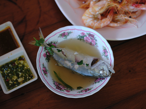 Thai sea food ,  clear spicy hot & sour soup (Tomyum) with boiled asian red tail cat fish fillet and herb .Daeng Seafood Restaurant (The real original shop for over 40 years)