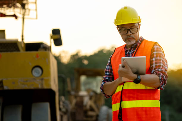 istock Male engineer uses tablet to plan work in road construction area 1829917982