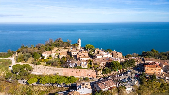An aerial view of the small medieval village of Fiorenzuola di Focara immersed in the San Bartolo park in the province of Pesaro and Urbino