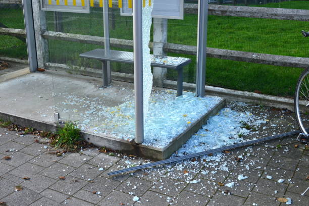 Broken glaze wall outdoors Broken safety glass of a bus station on the ground and metal bench due to an accident or voluntary damage due to vandalism bus shelter stock pictures, royalty-free photos & images