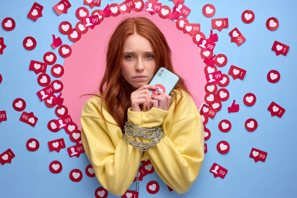 istock redhead woman obsessed with internet. female hands tied with chain, having no interest other than smartphone 1829951183