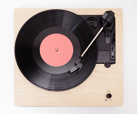 Top view of vintage portable record player playing a black vynil record