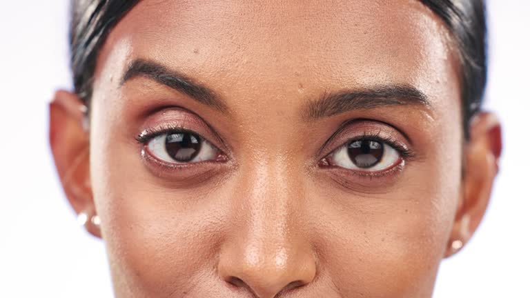 Face, eyes and woman with closeup, wellness and eye care with clear vision on a white studio background. Person, model and girl with retina, optometry and iris with lashes, health and aesthetic