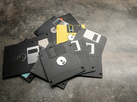 From above a pile of floppy disks placed on a grey background.
