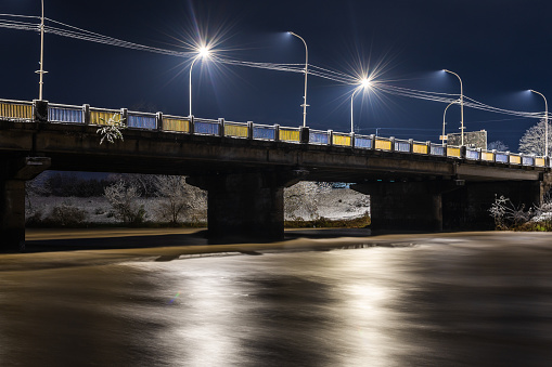 Winter night landscape of the bridge over the Uzh river in Uzhgorod