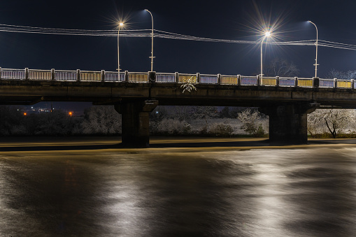 Winter night landscape of the bridge over the Uzh river in Uzhgorod