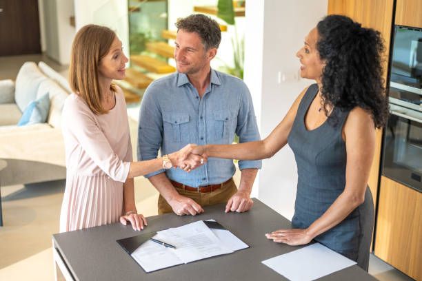istock Couple and real estate agent handshake 1829978435