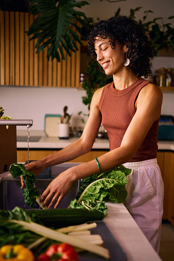 Health Enthusiast Woman Washing Fresh Vegetables for a Nutritious Vitamin-Rich Meal in a Modern Kitchen