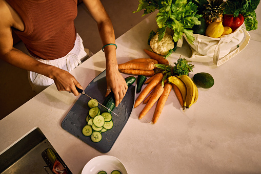 Focused Individual Preparing A Healthy Meal With Organic Vegetables On A Modern Kitchen Counter, Highlighting The Importance Of Nutritious Home-Cooked Food And Sustainable Eating Habits