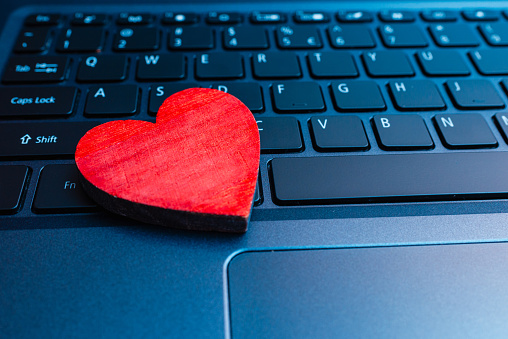 Concept online dating.Online date. Heart on laptop computer keyboard.Closeup.